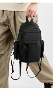 Detail of a black multi-pocket crossbody bag in ripstop nylon with adjustable strap