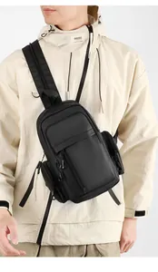 Vertical model shot of black waterproof nylon crossbody bag with adjustable wide shoulder strap