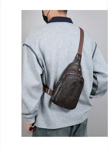 Macro detail of men's dark brown sling bag featuring premium crocodile embossed texture