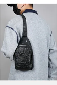 Detail of men's crocodile pattern chest bag showing texture and crossbody wear on model