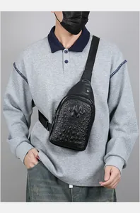 Close-up of black crocodile texture PU leather chest bag for men with metal buckle details