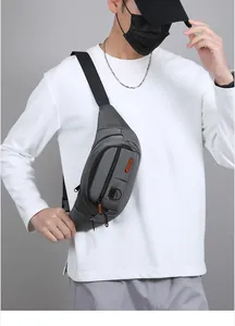Detail view of the gray multi-pocket chest bag with orange fashion labels and straps