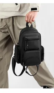 Vue détaillée du sac à dos tactique noir durable avec plusieurs poches zippées