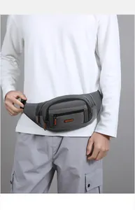Detail of dark grey waterproof waist bag showing zipper compartments and buckle strap