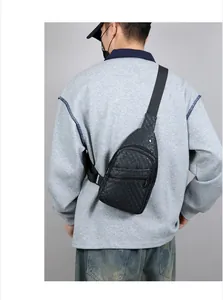 Detail of black faux leather sling bag with crocodile texture on male model