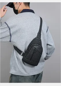 Rear view of a man wearing a black crocodile pattern chest bag with adjustable strap