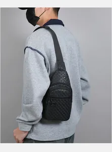 Detail of black crossbody chest bag featuring a textured geometric weave pattern and metal zipper