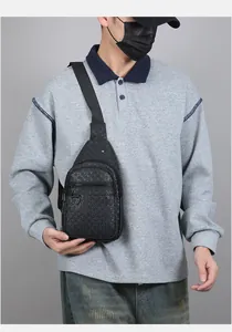 Close-up of black PU leather chest bag featuring geometric texture and multiple zipper pockets