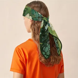 Foulard en soie avec peinture florale noué dans les cheveux comme accessoire élégant