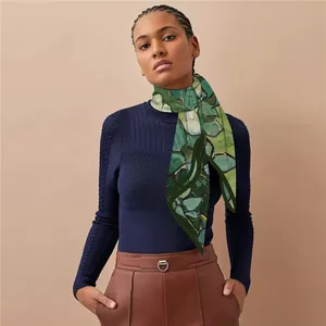 Détail d'un foulard en soie au motif de peinture à l'huile porté sur un pull bleu marine
