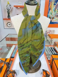 Close-up of silk scarf showing handcrafted rolled edges and landscape painting texture