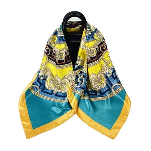 Baroque silk scarf with yellow and blue geometric patterns draped on a black handbag