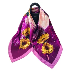 Detailansicht eines Satin-Halstuchs mit Sonnenblumenmuster auf einer luxuriösen Tasche