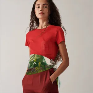 Close-up of a floral print silk scarf tied as a belt on red cotton t-shirt outfit