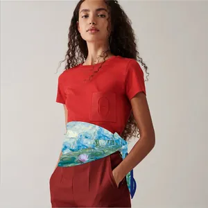 Detail of silk scarf with impressionist water lily print on red trousers