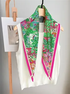 Detail view of floral silk scarf with tropical palm leaves on white knit vest