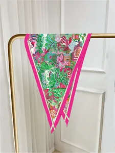 Detailed close-up of colorful tropical botanical print silk scarf on a golden hanger