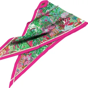 Close-up of folded silk scarf featuring tropical palm leaves and floral garden patterns