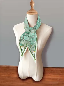 Detail of silk scarf with tropical botanical patterns tied on a mannequin neck