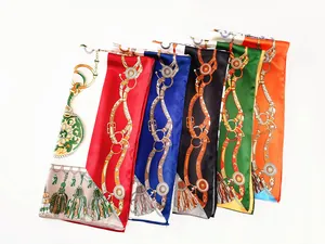 Detail showing various silk-like scarves with equestrian horseshoe and tassel patterns