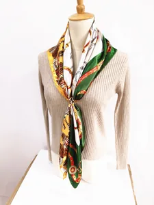 Silk scarf featuring vintage equestrian motifs tied on a sweater with metal ring buckle