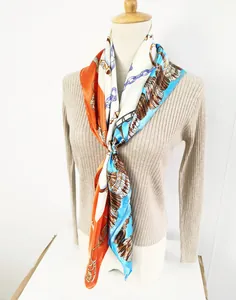 Detail of silk scarf with chain and feather prints on a mannequin for styling