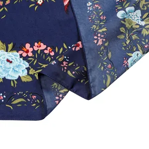Détail d'un foulard en soie bleu marine avec des motifs floraux et oiseaux vintage