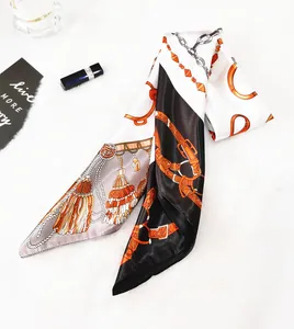 Detail of silk twilly scarf featuring horse bit chain patterns and tassel prints