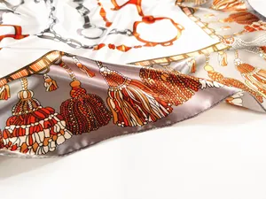 Close-up of silk scarf showing vintage horsebit, chain patterns and tassel details