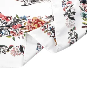 Détails de motifs oiseaux et roses sur foulard en soie blanche avec bords roulés