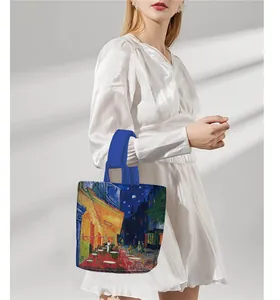 Outdoor lifestyle view of Van Gogh Cafe Terrace printed tote bag with royal blue handles