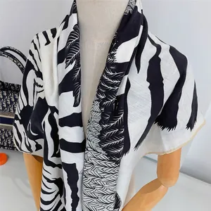 Detailansicht eines großen Schals mit Zebra-Print und tropischen Blattmustern auf Stoff