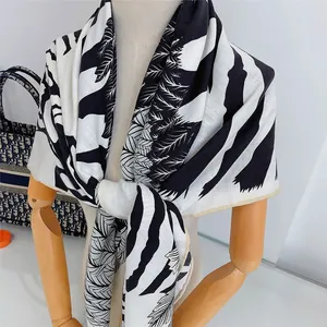 Detail eines bedruckten Schals mit Palmblattmustern und Zebrastreifen auf weichem Stoff