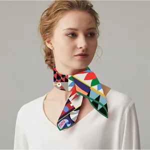 Gros plan d'un foulard twilly coloré avec motifs de perroquets et lettrage PARIS