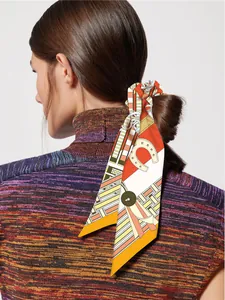 Detail of silk twilly hair scarf with equestrian horseshoe print tied on a ponytail