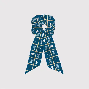 Détail d'un chouchou en soie bleu marine avec motifs équestres dorés et chevaux