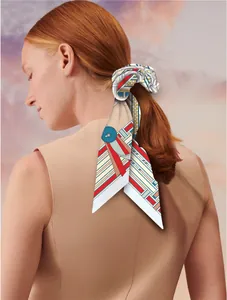 Close-up of silk scarf with geometric patterns tied as a hair ribbon on a ponytail