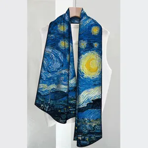 Détail du long foulard en soie Nuit Étoilée drapé sur un gilet blanc et un cintre en bois