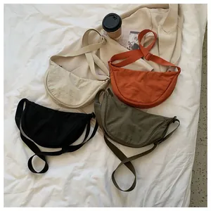 Flat lay of colorful waterproof oxford half-moon crossbody bags with adjustable straps