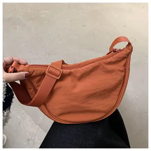 Close-up of orange waterproof nylon crescent crossbody bag with adjustable wide strap