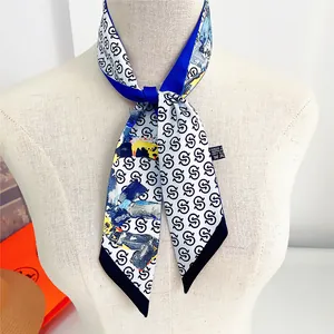 Detail of a silky twilly scarf with blue panels and geometric letter print shown on a bust