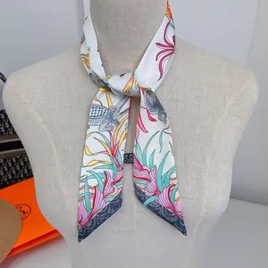 Detail of the tropical flora and crocodile print on a silk twilly tied on a mannequin