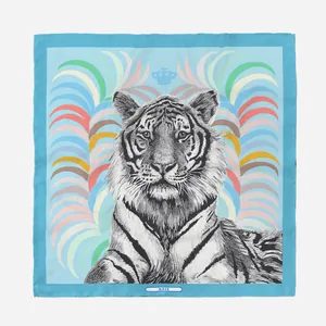 Detalle de un pañuelo de seda con estampado de cabeza de tigre y etiqueta PARIS azul