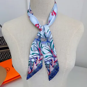 Close-up of light blue twilly scarf with floral patterns tied on a mannequin neck
