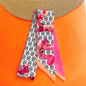 Detail of a white summer twilly scarf with pink lipstick patterns and black S letters