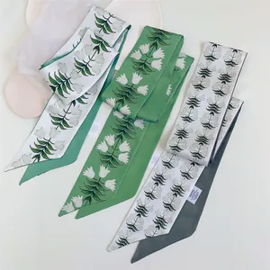 Detalle de bufandas largas con estampado floral de tulipanes verdes sobre tela