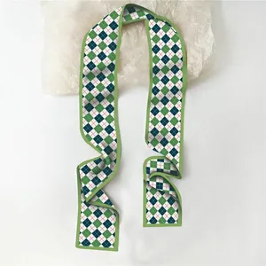 Détail d'un foulard en soie à motif argyle vert pour cheveux ou décoration de sac
