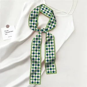 Détail d'un ruban en soie à carreaux vert noué en nœud sur une robe blanche élégante