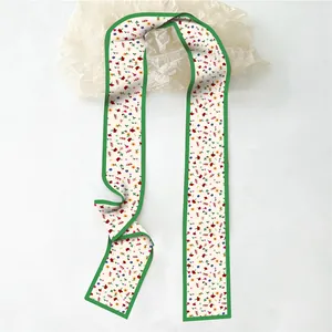 Vue détaillée d'un foulard twilly long à fleurs avec bord vert vif et coutures précises