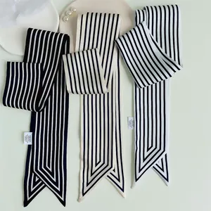 French style black and white striped silk scarf and hair tie on a white decorative plate